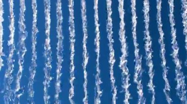 Su akıntılarının parlak mavi gökyüzüne karşı canlı görüntüsü, dinamik, soyut bir şablon yaratıyor doğa veya enerji temalı görseller için ideal.