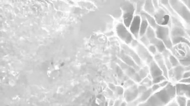 Su kabarcıklarının yakın çekimi ve pürüzsüz bir yüzeyde parıldayan ışık yansımaları. Yüksek karşıtlık ve berraklık sıvı dokulara ve parlak renklere vurgu yapar