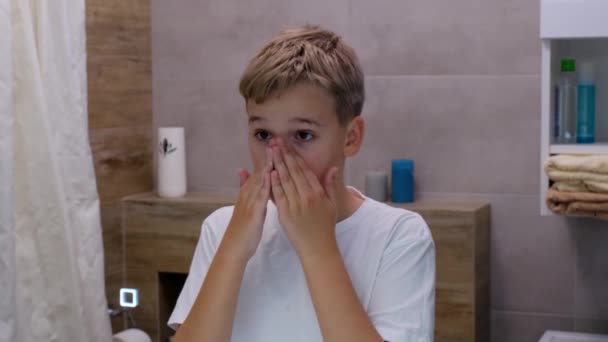 十几岁的男孩在家里用清洁剂洗脸 早上的皮肤护理 爱护洁净与美感 — 图库视频影像