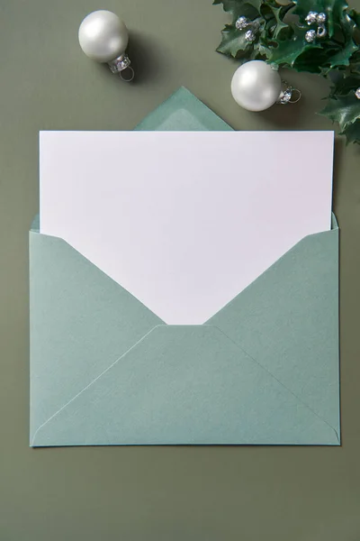 Christmas mock up for greeting card or letter. Xmas background with empty white paper in envelope. Copy space
