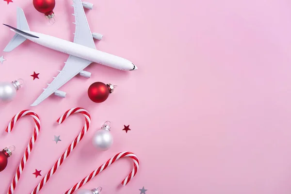 Kerstreis Concept Model Van Passagiersvliegtuig Snoepstokken Kerstversiering Roze Achtergrond Bovenaanzicht — Stockfoto