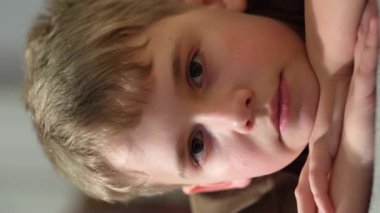 Kameraya bakıp gülümseyen ve göz kırpan sevimli bir genç. Yakın plan portre.