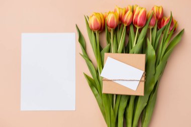 Vertical blank card mockup. Thank you card template with bouquet of tulips on a beige background.