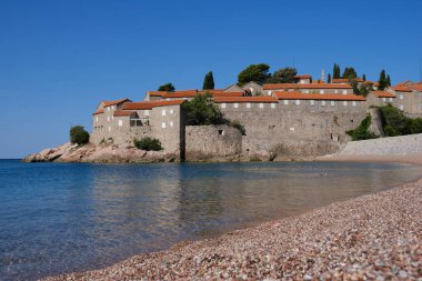 Karadağ 'ın güneşli yaz gününde Sveti Stefan adası yakınlarındaki güzel boş plaj. Adriyatik Denizi, Budva, Karadağ 'daki adada lüks turistik tatil beldesi.