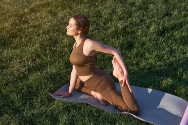Yoga ya da parkta açık hava sporları yapan güzel bir genç kadın. Sağlıklı yaşam tarzı ve uzatma kavramı.