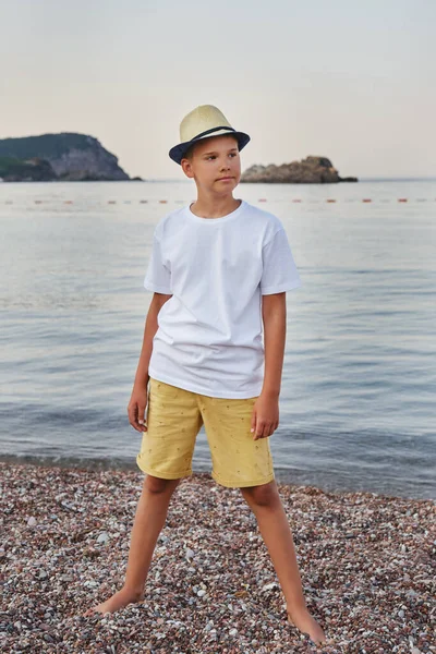 지푸라기 모자를 해변에 티셔츠를 소년의 초상화 여행이라는 — 스톡 사진