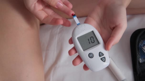 당뇨병을 십대는 집에서 침대에 포도당 측정기로 수준을 측정합니다 — 비디오