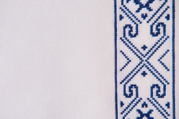 Texture of homespun linen textile with embroidery. Design of ethnic pattern. Craft embroidery. Geometric ornament.