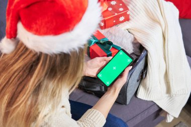 Bir kadın akıllı telefon ve kredi kartı kullanıyor. Başvuru ya da hizmet için bir model. Noel alışverişi ve indirimleri.