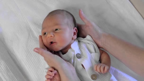 女性の手は新生児の頭を回します 母親や小児科医は子供の反射をチェックする 赤ちゃんの健康のためのお世話 — ストック動画