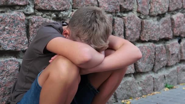 悲しみに落ち込んだ十代の少年だけ外の石の壁の近くで 怒りと孤独を感じる — ストック動画