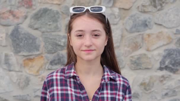 Ένα Χαμογελαστό Έφηβο Κορίτσι Κοιτάζει Την Κάμερα Και Δείχνει Μια — Αρχείο Βίντεο
