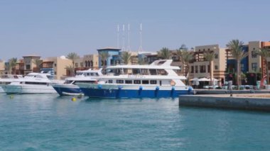 Lüks yatlar bir marinaya demirlemiş. Kıyıdaki lüks konutlara karşı..