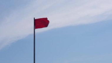 Fırtınadan önce sahilde uyarı işareti olarak kırmızı bayrak, rüzgarlı bir günde yüzemeyeceğiniz anlamına gelir.