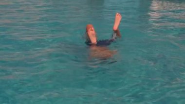 Güneşli bir günde Havuzda Baş Aşağı Duran Çocuk.