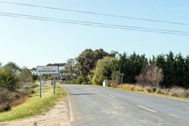 Batı Cape Bölgesi 'nde Gansbaai ve Elim arasındaki yolda Baarskeerdersbos girişinde isim tahtası var.