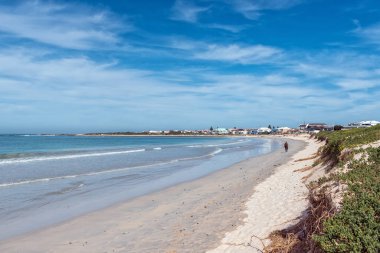 Struisbaai, Güney Afrika - 21 Sep 2022: Struisbaai, Batı Cape Eyaleti 'nde bir plaj sahnesi. Binalar ve bir kişi görünüyor.