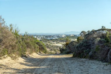 Arniston, Güney Afrika - 22 Ekim 2022: Batı Cape Eyaleti 'ndeki Waenhuiskrans Mağarası' ndan Arniston 'a kadar binalar ve insanlar merkezde görülebilir.