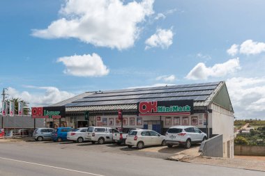 Napier, Güney Afrika - 23 Eylül 2022: Batı Cape Eyaleti Napier 'de bir süpermarket ve araçlarla bir sokak sahnesi. Güneş panelleri görünür.