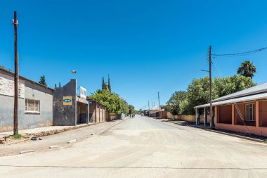 Petrusville, South Africa - Feb 21, 2023: A street scene, with buildings, people and vehicles, in Petrusville in the Northern Cape Province