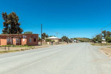Petrusville, South Africa - Feb 21, 2023: A street scene, with buildings, vehicles and people, in Petrusville in the Northern Cape Province