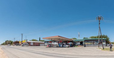 Douglas, Güney Afrika - 1 Mart 2023: Kuzey Cape Eyaleti Douglas 'ta bir benzin istasyonu, lastik atölyesi, insanlar ve araçlarla bir sokak sahnesi