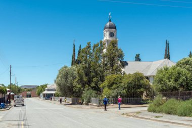 Petrusville, Güney Afrika - 21 Şubat 2022: Kuzey Cape Eyaleti 'ndeki Petrusville' de Hollanda Reform Kilisesi ve insanlarıyla bir sokak sahnesi