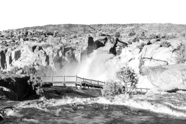 Orange River 'daki Augrabies şelalesinde tahta kaldırım. Nehir sel altında. Tek Renkli