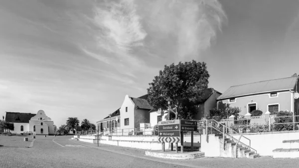 stock image Elim, South Africa - Sep 21, 2022: A street scene, with historic houses, a business and the Moravian Church, in Elim, in the Western Cape Province. Monochrome