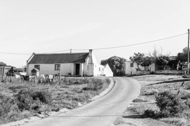 Arniston, Güney Afrika - 22 Ekim 2022: Kassiesbaai, Arniston 'da tarihi evlerle dolu bir sokak sahnesi. Tek Renkli