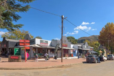 Clarens, Güney Afrika - 4 Mayıs 2025 Clarens 'de bir sokak sahnesi. İş yerleri, insanlar ve araçlar görünür.