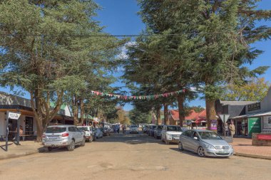 Clarens, Güney Afrika - 4 Mayıs 2025 Clarens 'de bir sokak sahnesi. İş yerleri, insanlar ve araçlar görünür.