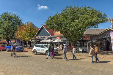Clarens, Güney Afrika - 4 Mayıs 2025 Clarens 'de bir sokak sahnesi. İş yerleri, insanlar, bisikletçiler ve araçlar görünür