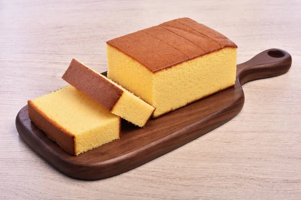 卡斯特拉 卡索特拉 木制盘子上美味的切片蜂蜜海绵蛋糕 免版税图库照片