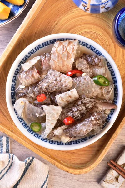 Cold fish skin in sauce in a bowl on a wooden table