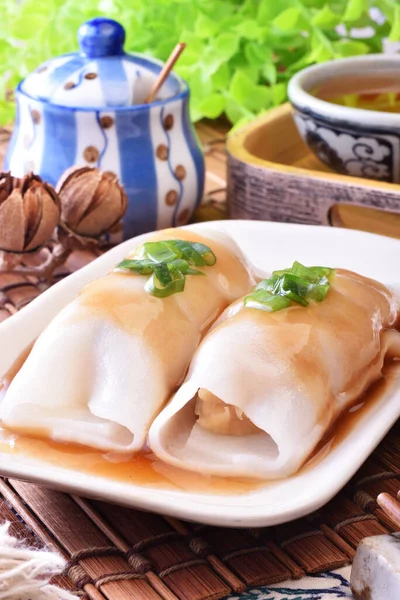 Steamed rice rolls with fresh prawn filling served in a dish  on wooden table