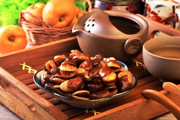 在木制桌子上的盘子里烤盐蚕豆 — 图库照片