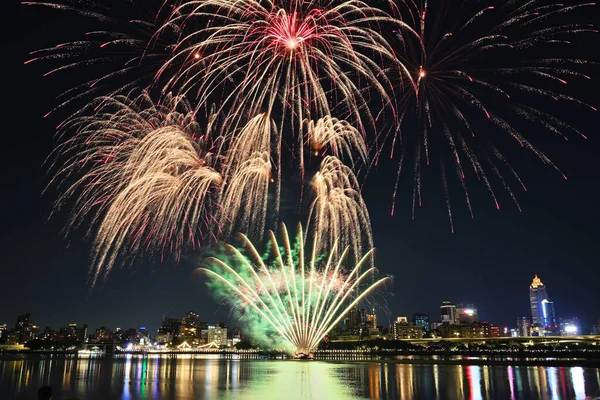 夜に川沿いの花火が披露される — ストック写真