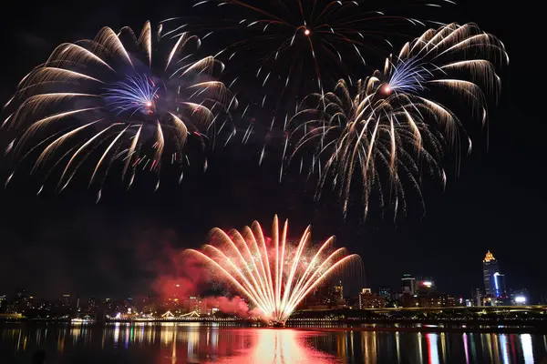 夜に川沿いの花火が披露される — ストック写真