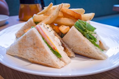 Beyaz tabakta mantarlı yumurtalı sandviç.