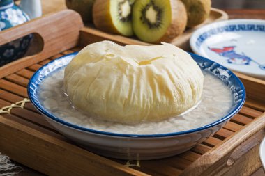 Kahverengi şekerli çörekli tatlı fıstık çorbası ahşap masada bir kasede  