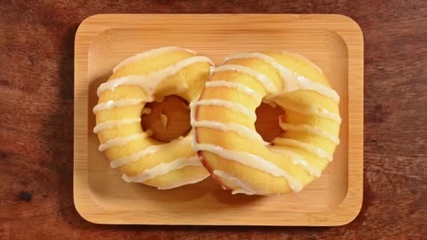 Donut Mit Weißem Zuckerguss Auf Holzteller Auf Holztischhintergrund Stock-Filmmaterial