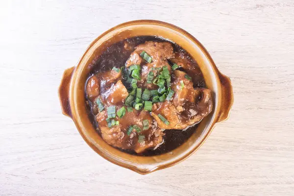 Stewed pork trotters in brown sauce in clay pot