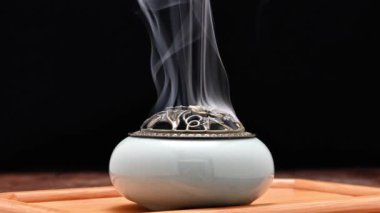 Tütsü, tütsü ocağında yakılır. Masanın üzerinde, koyu arkaplanda. Din kavramı. Dikey Görüntü 