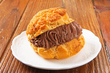 Beyaz tabakta çikolata kremalı profiterol. .  
