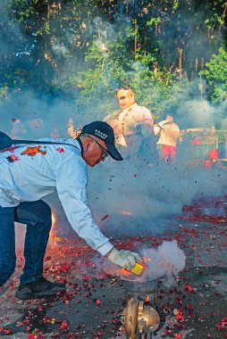 Taipei, Taiwan - July 21,2024 : The li-pow in the temple fairli-pow refers to using a stove to heat the pig iron sheets of the plowshare at high temperature, then lighting the cannon in a streaking manner and throwing it under the mikoshi.  clipart