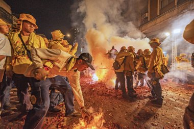 Taipei, Taiwan - July 21,2024 : The li-pow in the temple fairli-pow refers to using a stove to heat the pig iron sheets of the plowshare at high temperature, then lighting the cannon in a streaking manner and throwing it under the mikoshi.  clipart