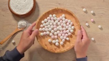 Tangyuan yapmak (Çin tatlısı). Tahtadaki beyaz ve pembe pirinç topları kaynamaya hazır olun.    