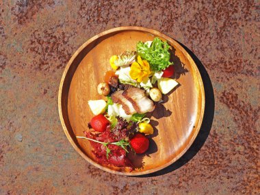 Köy ahşap tabağında ızgara et ve sebzeli salata.   