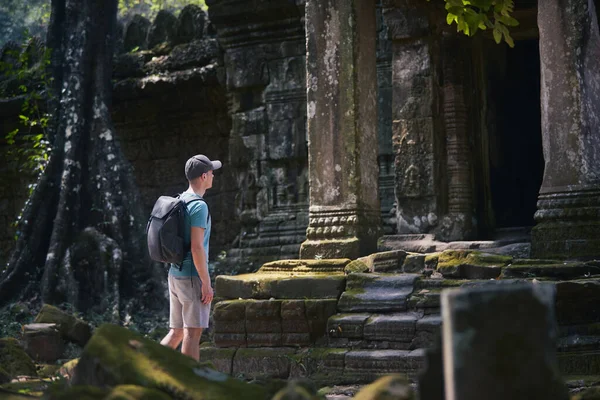 バックパックを持つ男は古代の寺院に来る カンボジアの旅行者 — ストック写真